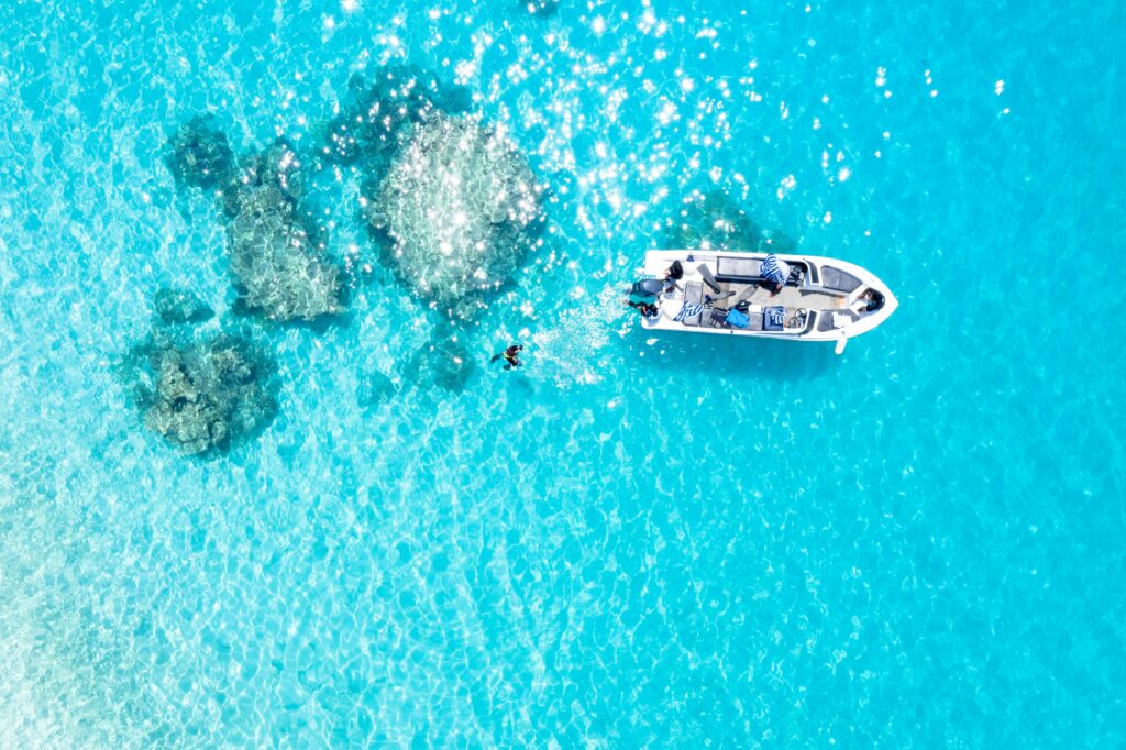 Aerial view of snorkeler exploring coral reef in turquoise waters Maldives budget snorkeling excursion